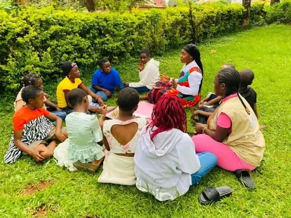 Participants and MOHCAM volunteers seated in a circle during a group discussion